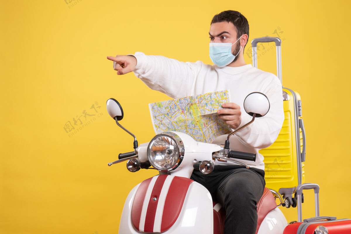 医疗旅行概念 戴着医用面罩的年轻人坐在摩托车上 黄色手提箱在上面坐着人玩家