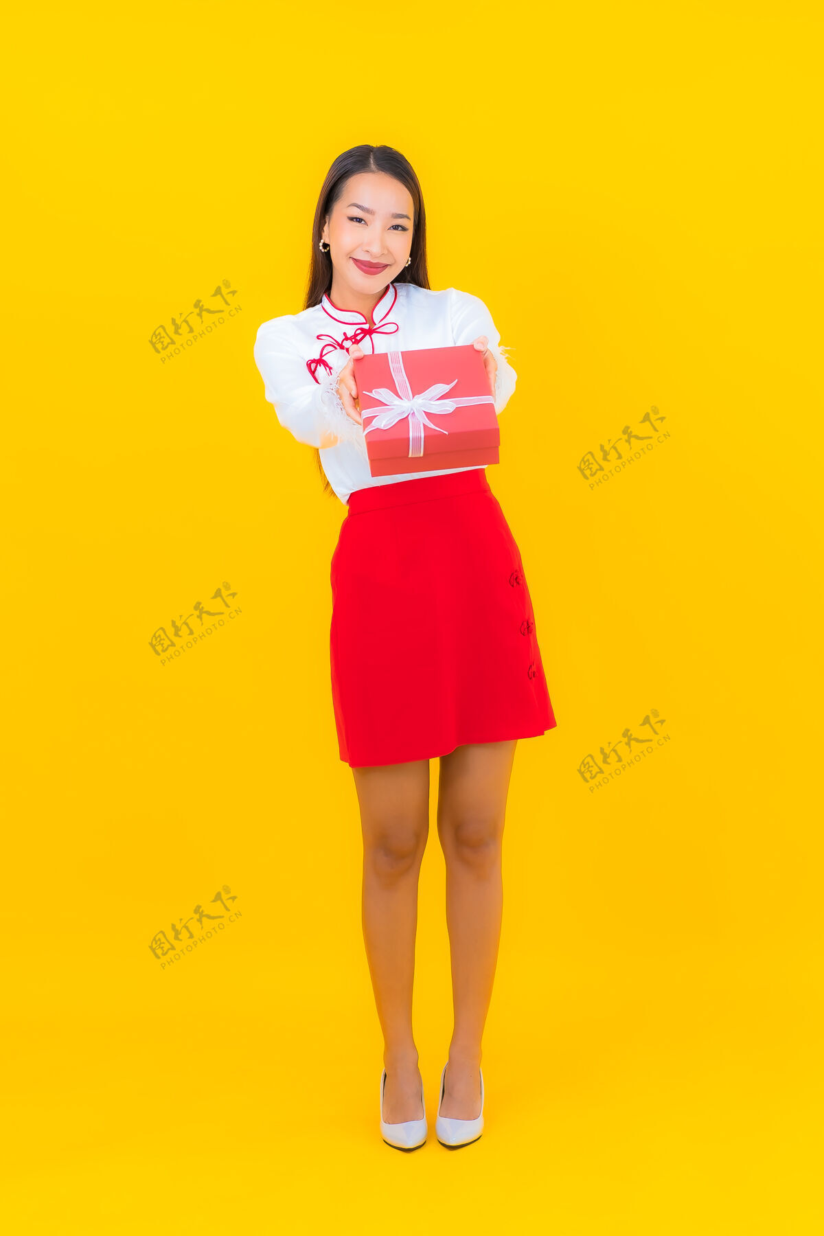 中国肖像美丽的亚洲年轻女子与红色礼盒黄色礼物给予泰国