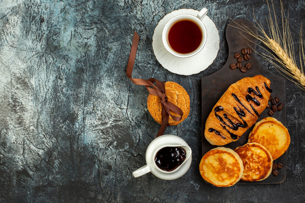 咖啡因一杯茶和美味的早餐的俯视图 深色的桌子上有烤薄饼咖啡美味的早餐煎饼