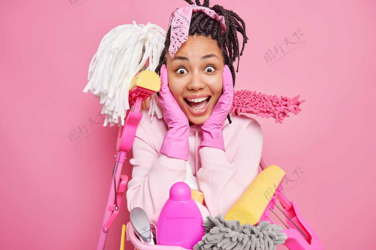 干净男子抓起面部用品与清洁服务所需的设备周围打扫房间隔离在粉红色年轻咯咯笑洗衣