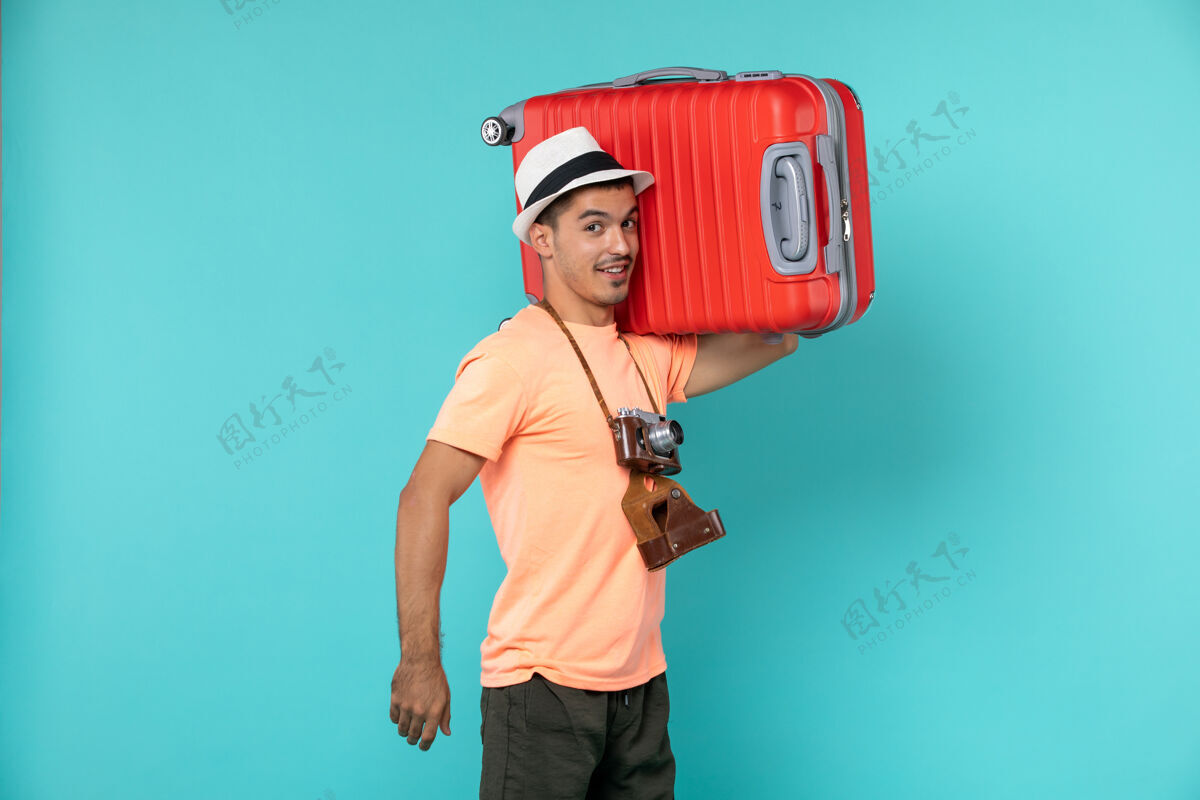 红色带着红色手提箱和蓝色相机的度假男人旅程航行人