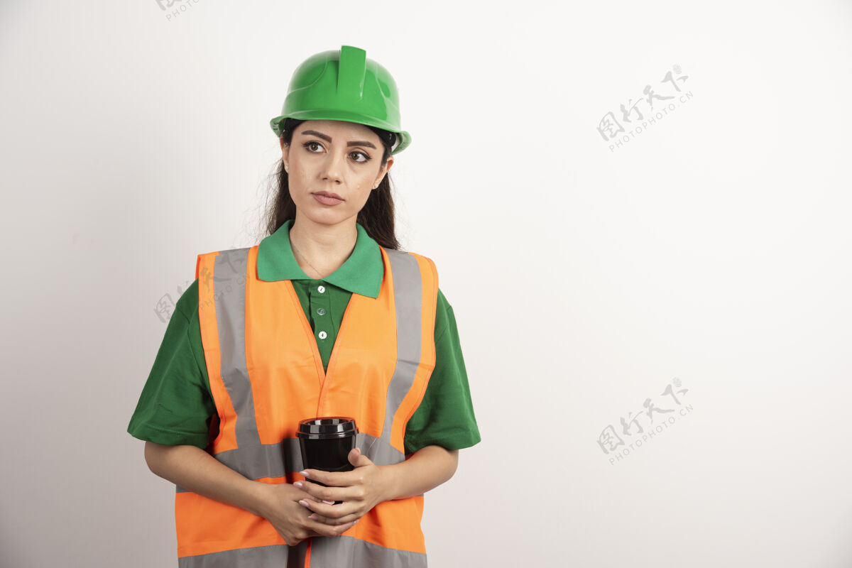 女人年轻的女建造师拿着黑色的杯子望着别处高质量的照片建筑师开发专业