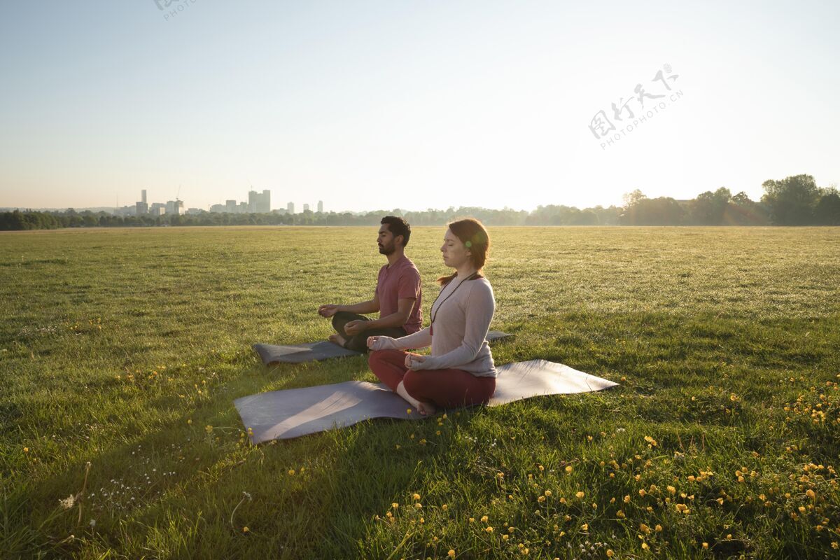 瑜伽男女在户外瑜伽垫上冥想的侧视图禅宗集中瑜伽垫