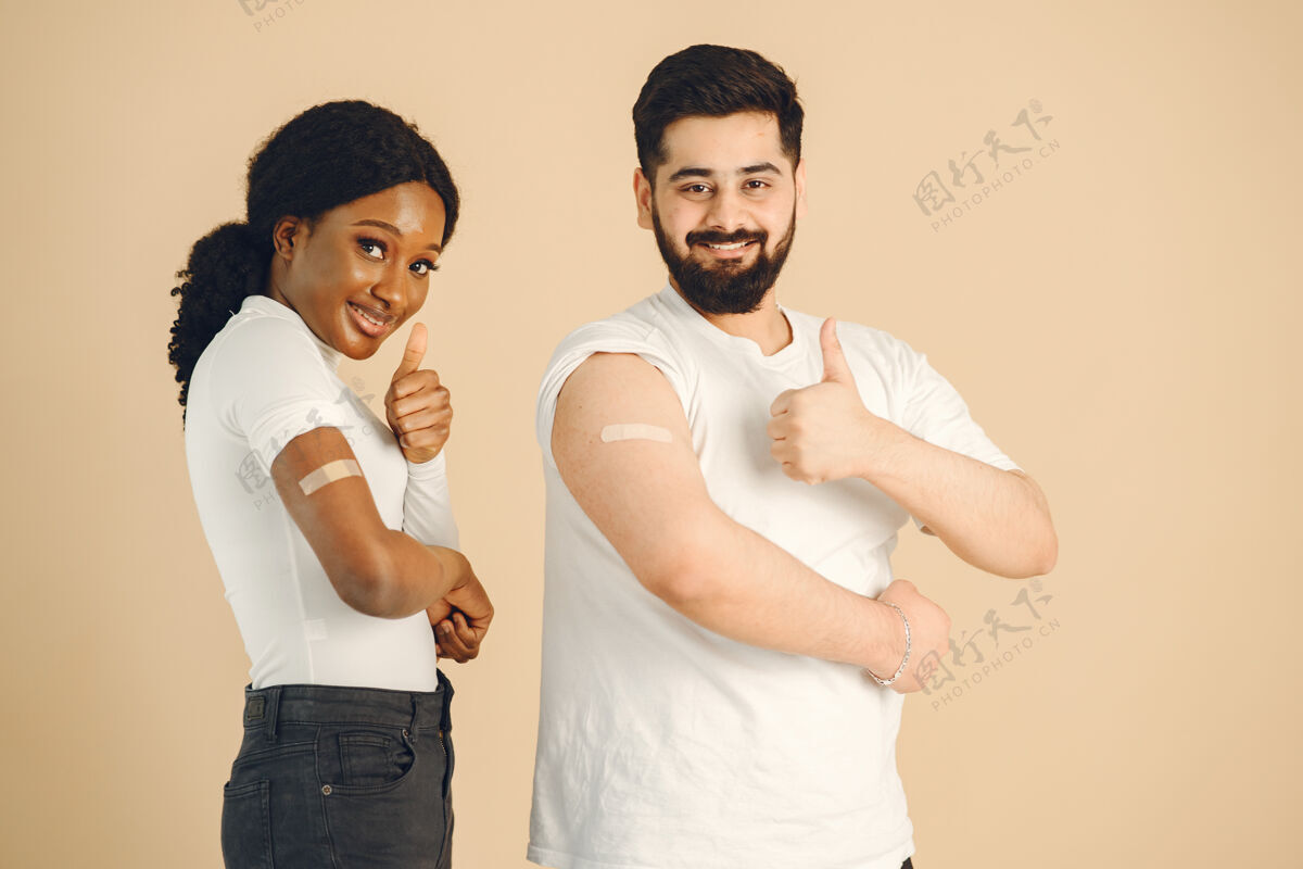 疾病孤立的 米色背景非洲妇女和男子竖起大拇指接种疫苗病毒流感疫苗