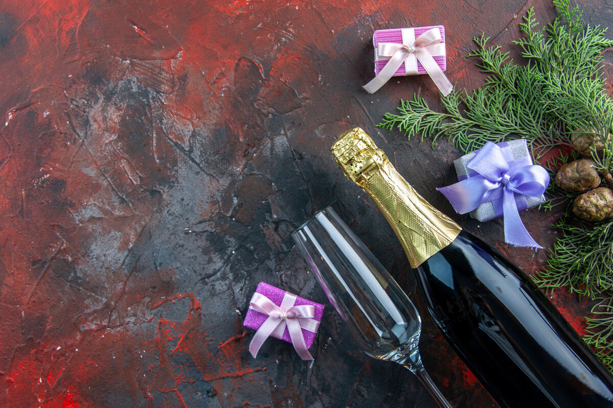 工具顶视一瓶香槟与小礼物上的深色饮料酒精照片新年派对聚会画笔容器