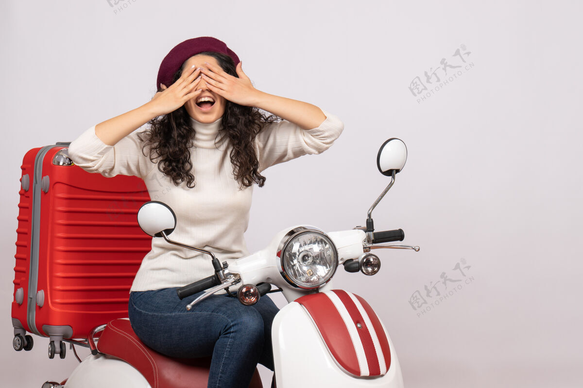 高尔夫正面图年轻女子骑在自行车上 脸上蒙着白色背景女子车速度假摩托车道路城市色彩自行车摩托车车辆