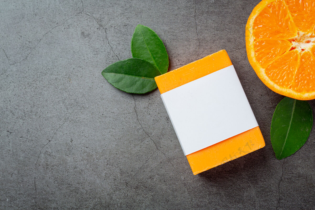 卫生橙色肥皂与新鲜的橙色在黑暗的背景产品皮肤护理肥皂