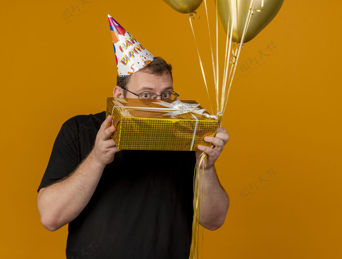 帽子令人印象深刻的成年斯拉夫人戴着眼镜戴着生日帽手持氦气球和礼盒氦空间礼物