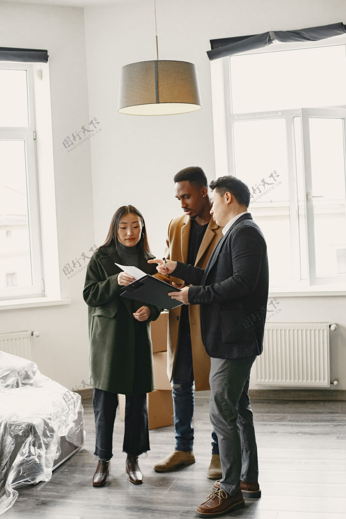 男性一对年轻夫妇正在买一套新房子亚洲女人和非洲男人在新家签署文件购买建筑师合同