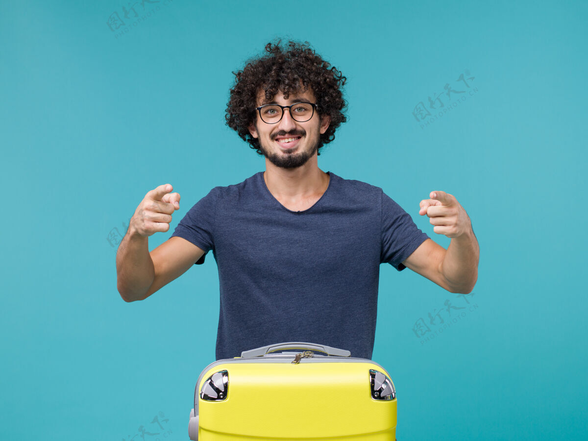 哑铃带着大黄色手提箱的男人在度假 心情愉快成人肖像蓝色