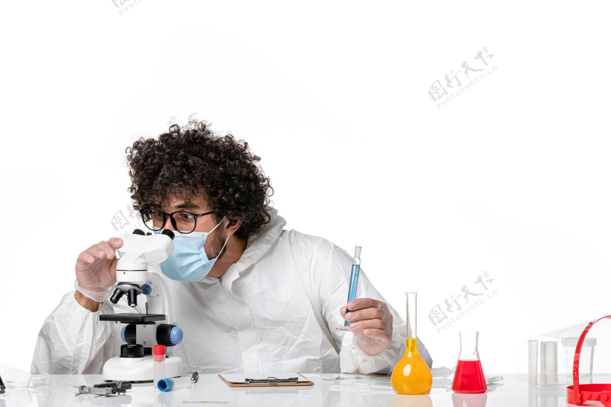 人男医生穿着防护服 戴着口罩 用显微镜对着白色使用显微镜流行病
