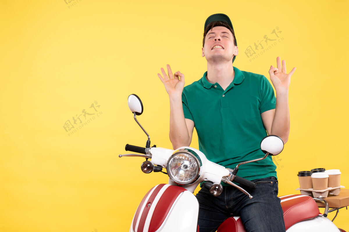 工人正面图：穿着绿色制服骑着黄色自行车的年轻男信使车辆活动制服