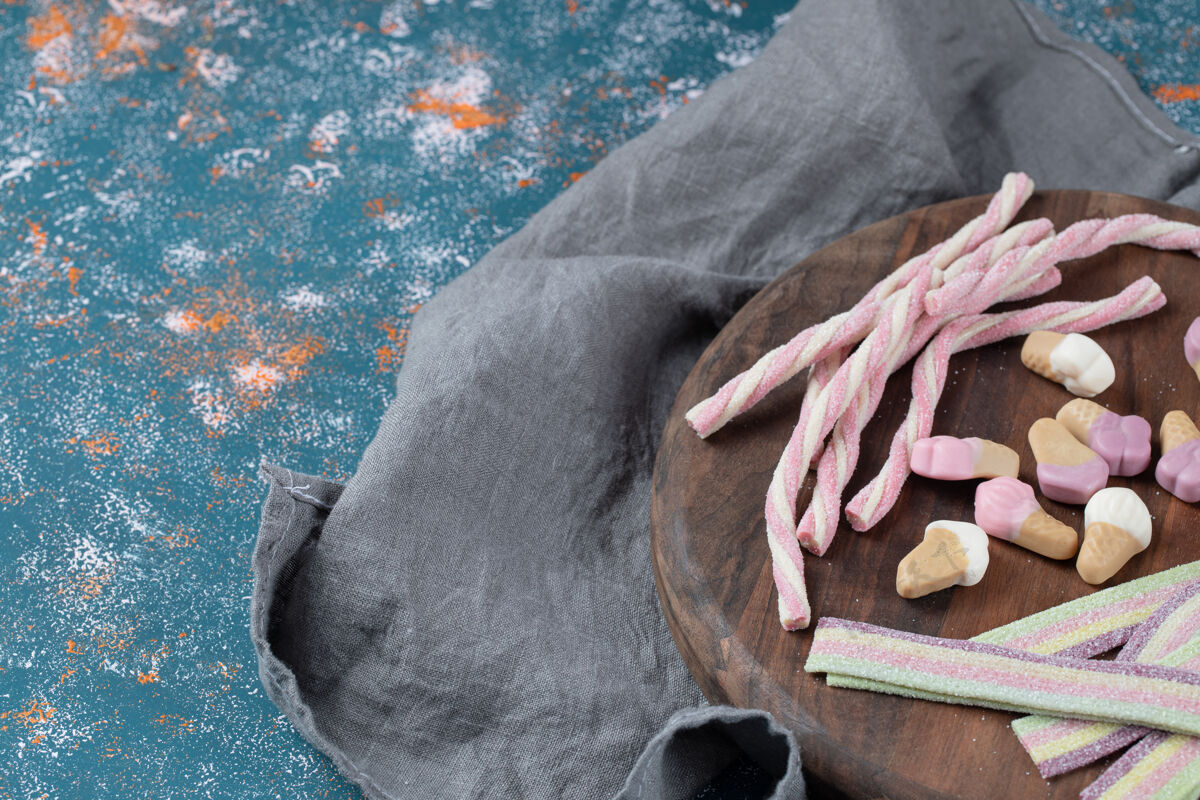 果皮长的 螺旋形和冰淇淋形状的果冻放在木板上果酱糕点顶视图