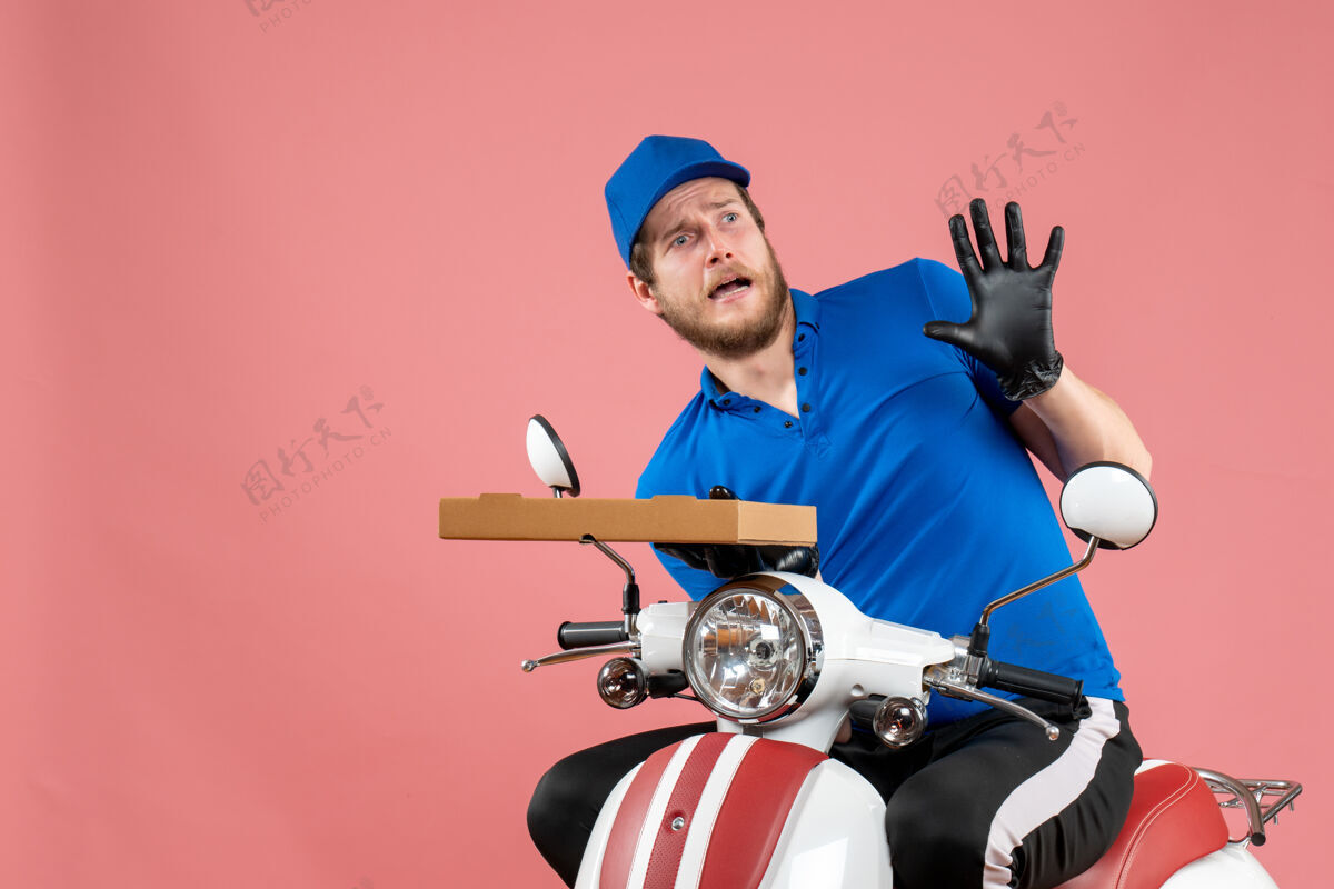 工作正面图男性信使坐在自行车上 拿着粉红色的比萨饼盒人制服工人