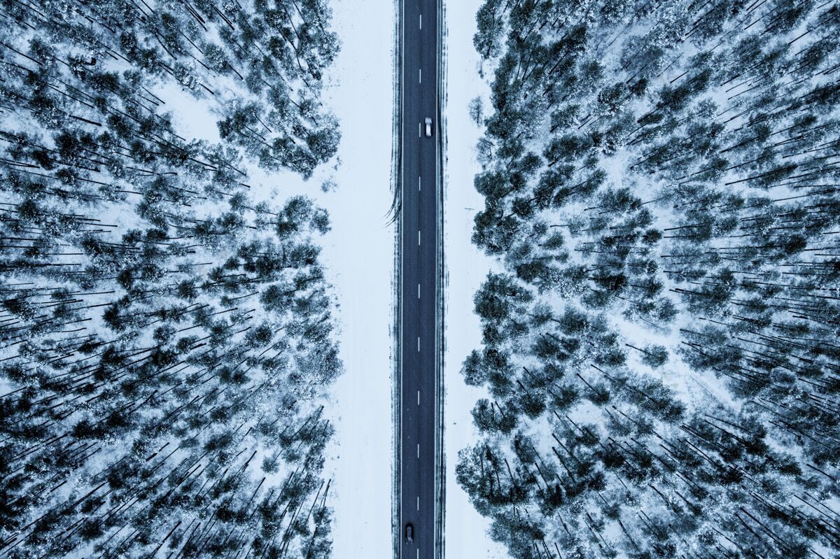 风景空中拍摄的道路在森林覆盖在冬天的雪环境美丽天气