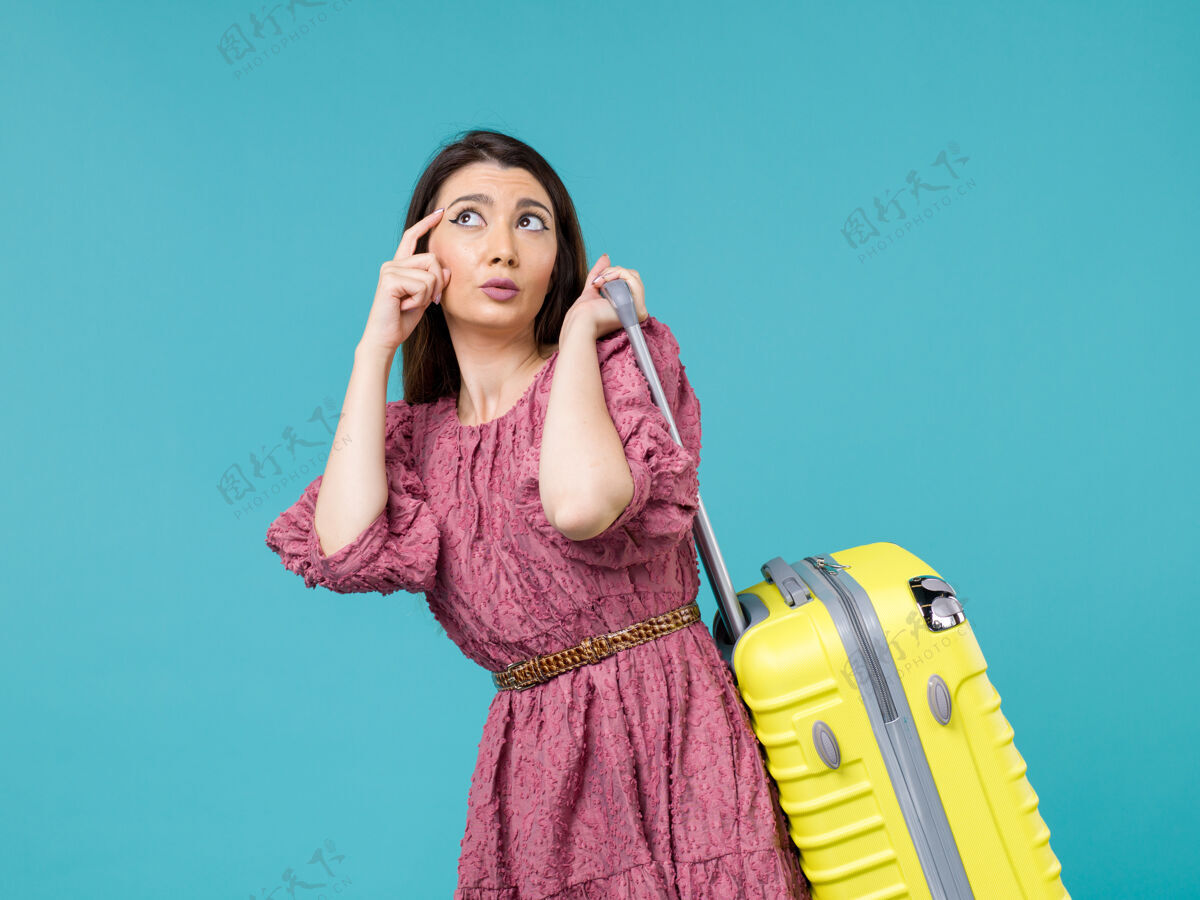 大前景年轻女子带着她的大袋子去度假蓝色背景旅行夏日旅行女人海人年轻的女人旅程头发