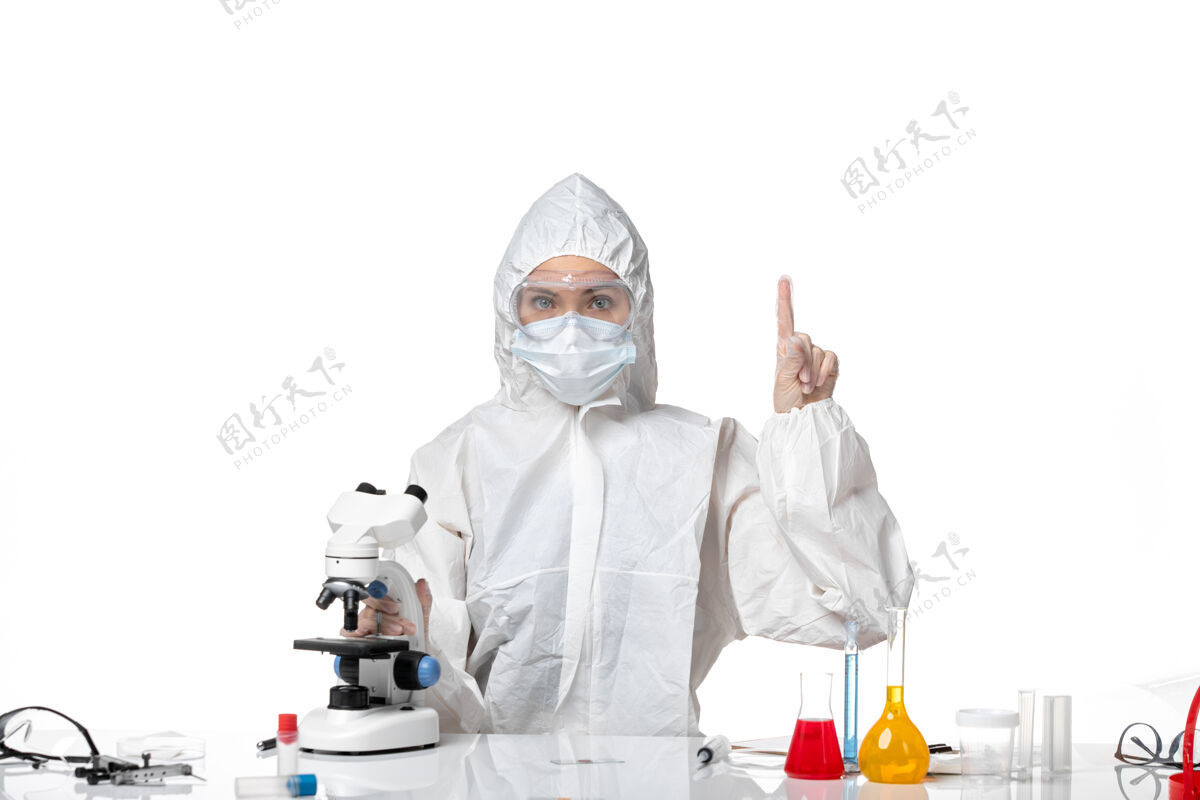 专业人员正面图年轻女医生穿着白色防护服 戴着口罩 由于科维德在白色背景上工作 大流行飞溅病毒健康科维德-医疗制服年轻女医生