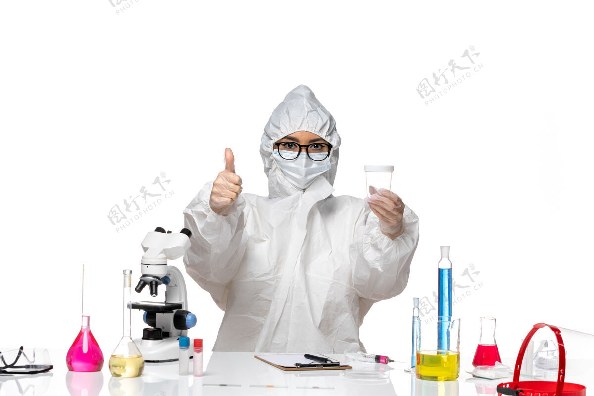 药正面图身穿特殊防护服的年轻女化学家拿着空瓶子 背景是白色的实验室冠状病毒-化学病毒人化学保持