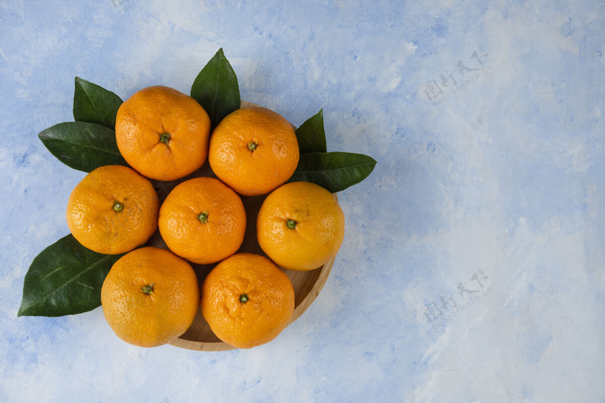 水果木盘上的一堆胡桃和树叶有机冬季柑橘