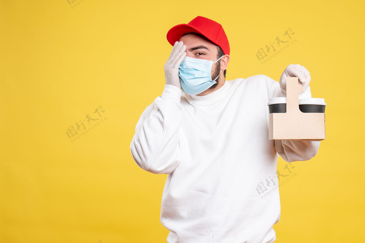 医生戴着面具的男信使拿着黄色的送咖啡送货医疗大流行