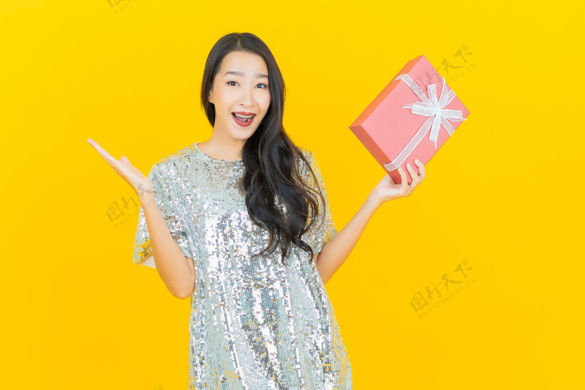 蓝色肖像美丽的亚洲年轻女子微笑红色礼盒上的黄色无忧无虑亚洲节日