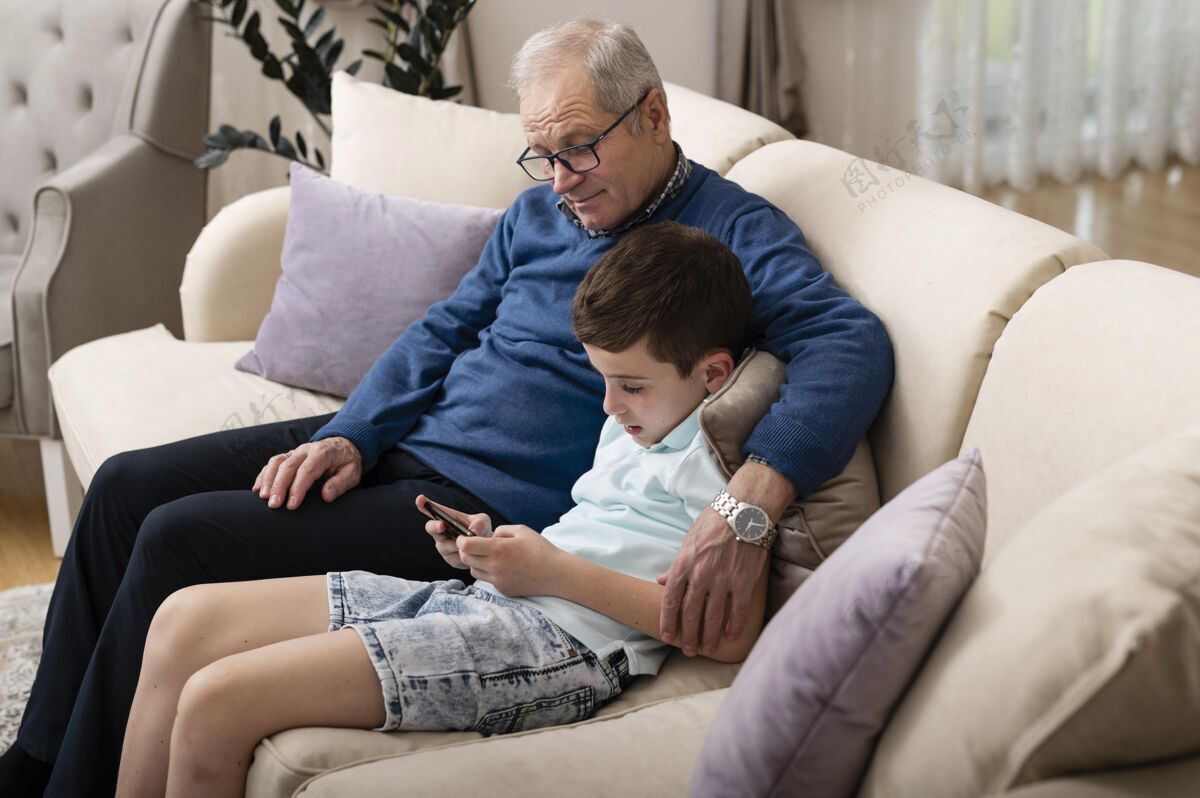世代孙子和爷爷在沙发上放松孩子水平在家