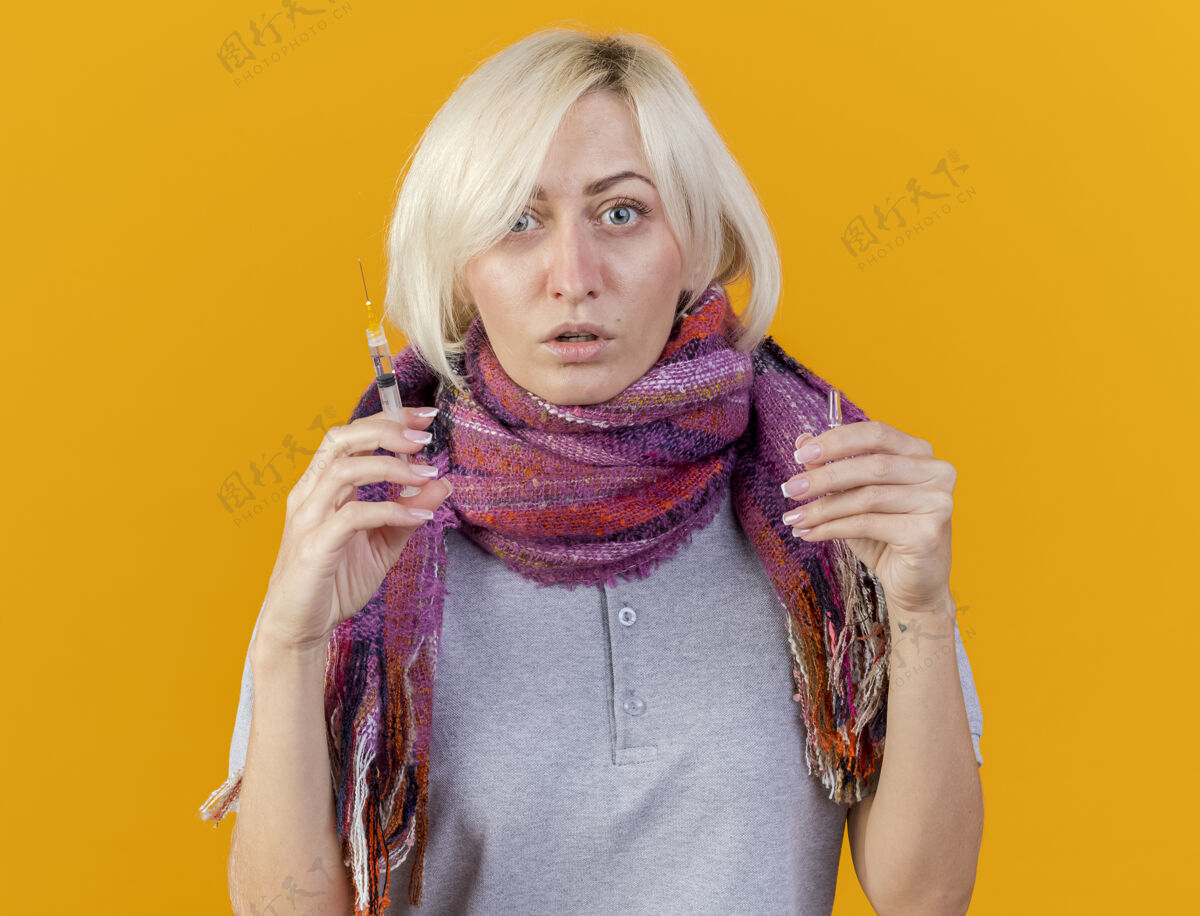 疾病自信的年轻金发病斯拉夫女人戴着围巾拿着注射器女人注射器围巾