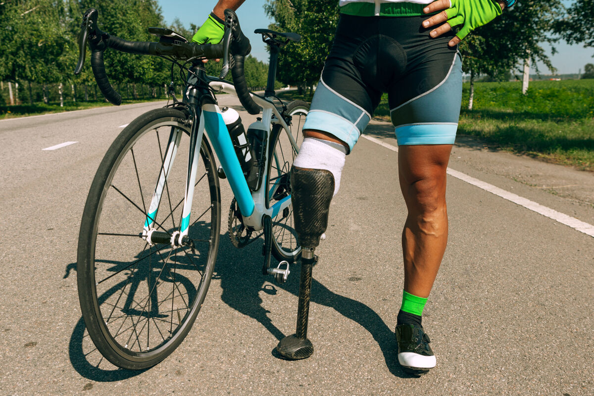截肢残疾运动员或截肢者在阳光明媚的夏日进行自行车训练专业男性运动员带假肢在户外练习残疾运动和健康的生活方式理念城市人工物理