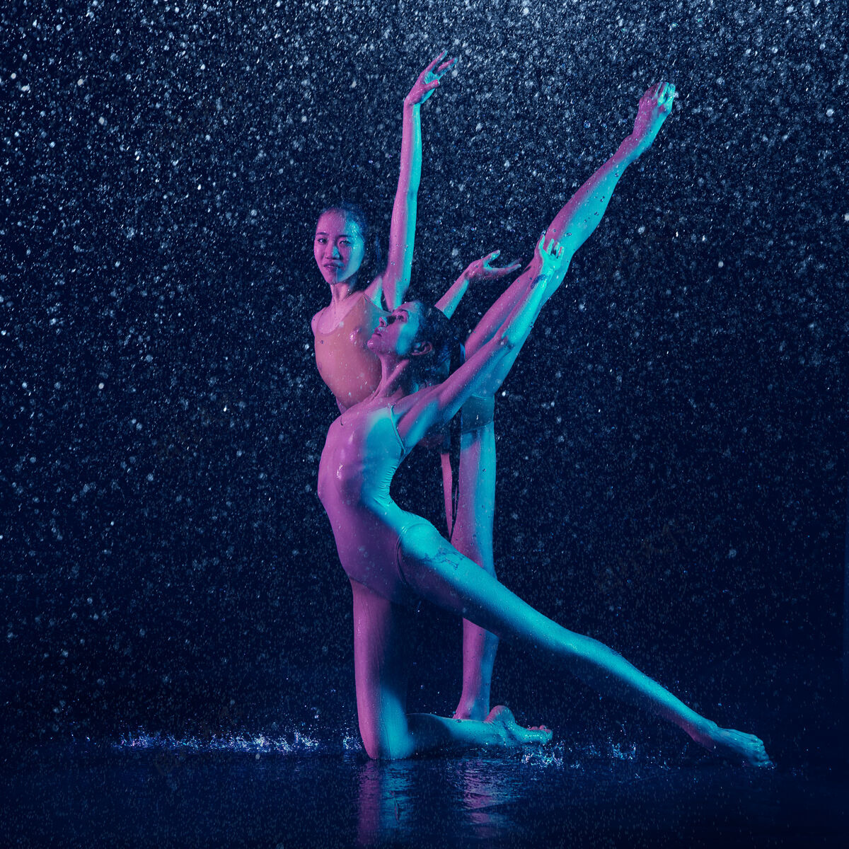 赤脚两个年轻的女芭蕾舞演员在水滴下身体女孩人