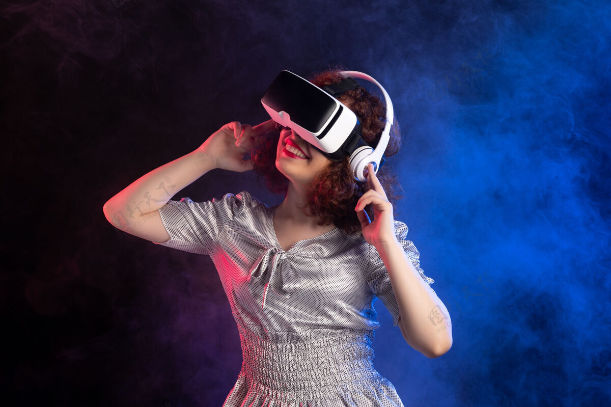 年轻女性年轻女性戴着vr耳机在深蓝色的耳机表面人物耳机虚拟现实