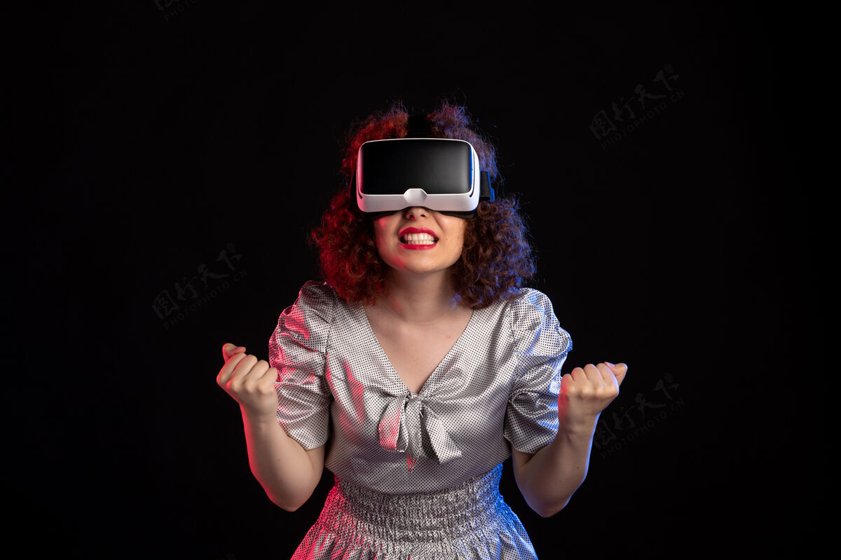 黑暗年轻女性戴着虚拟现实耳机在黑暗的表面视觉耳机虚拟