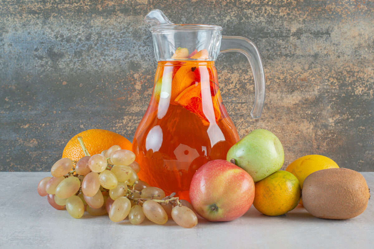 玻璃杯大理石上放着水果的玻璃罐果汁橘子苹果多汁