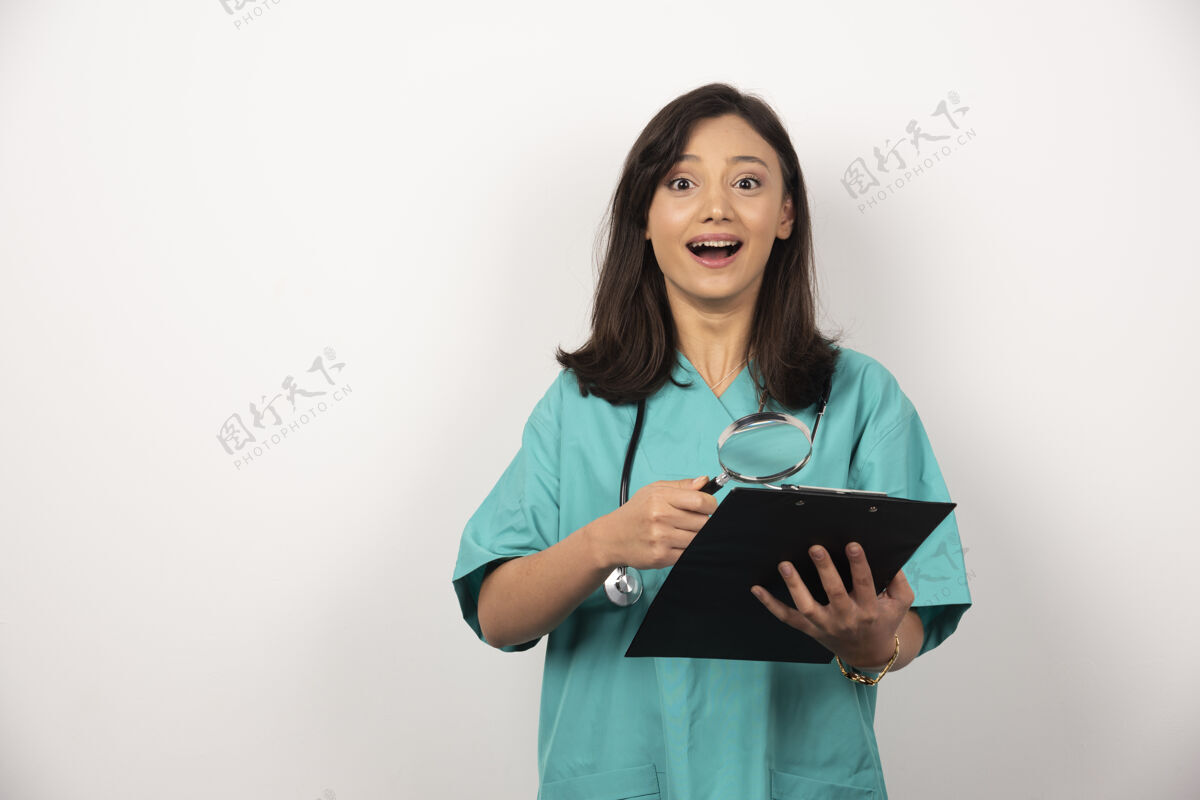 工作快乐医生与剪贴板和放大镜上的白色背景高品质的照片女性持有放大镜