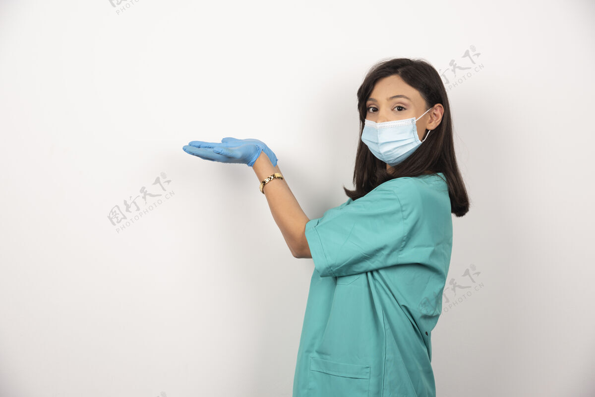 妇女戴着医用面罩和手套的年轻医生在白色背景上张开双手高质量照片女性医生保健