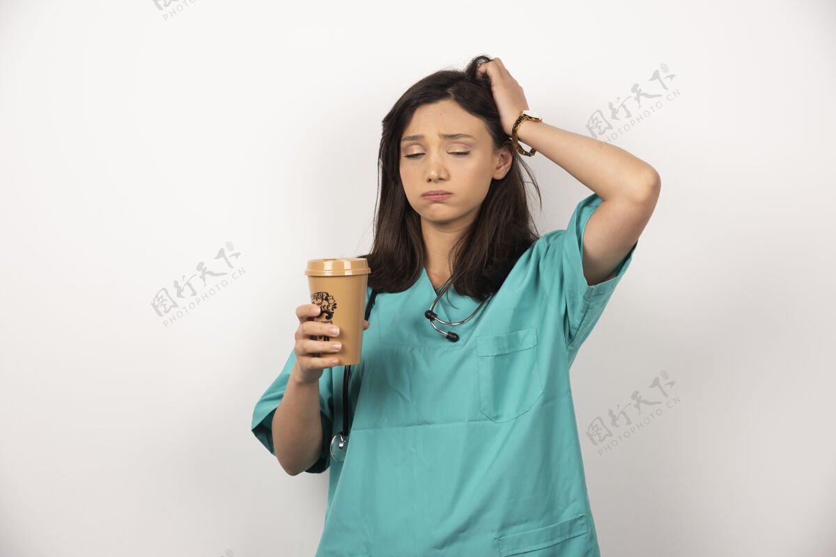 杯子疲惫的医生与一杯咖啡睡在白色的背景高品质的照片工人制服工作