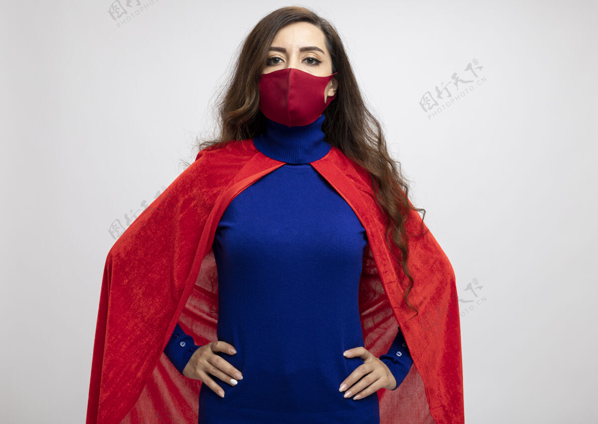 超级英雄自信的高加索超级英雄女孩 穿着红色斗篷 戴着红色防护面具腰斗篷手