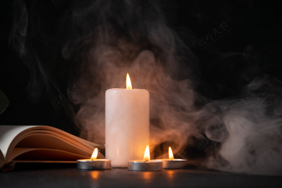 夜黑暗表面上燃烧的蜡烛的正面图风景燃烧葬礼