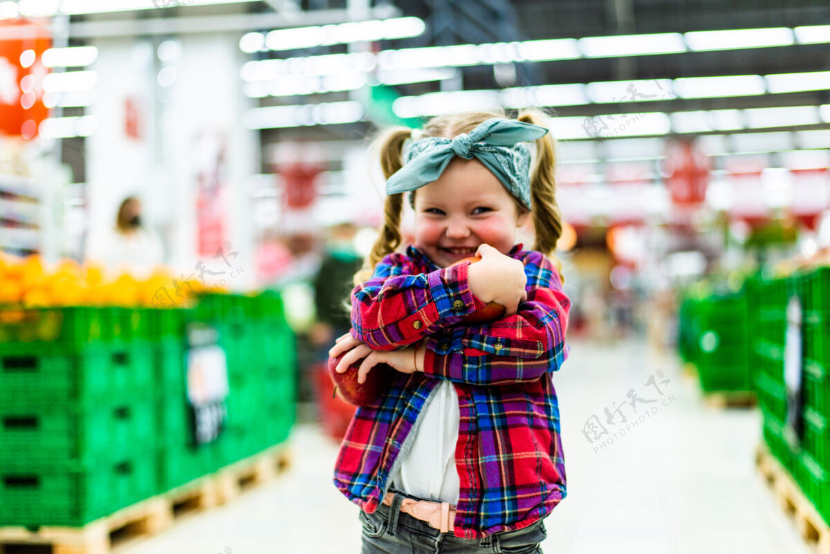 女孩小女孩在食品店或超市挑选苹果快乐杂货店孩子