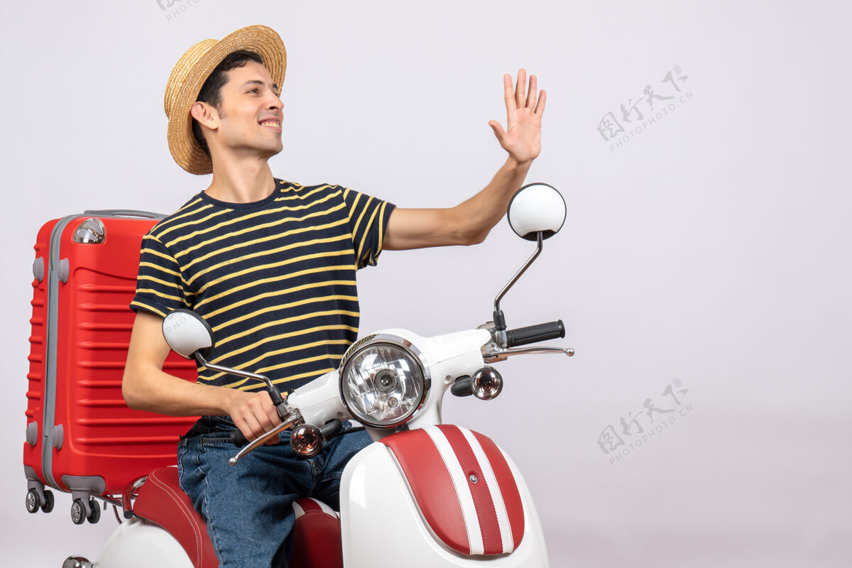 冰雹骑着轻便摩托车戴着草帽的年轻人招呼某人的正面图传送带微笑轻便摩托车