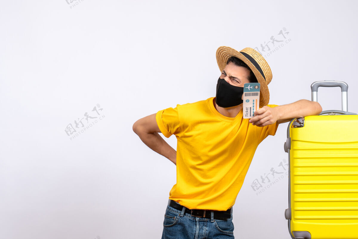 黄色正面图身穿黄色t恤的年轻旅客站在黄色手提箱旁举着机票男人视图T恤