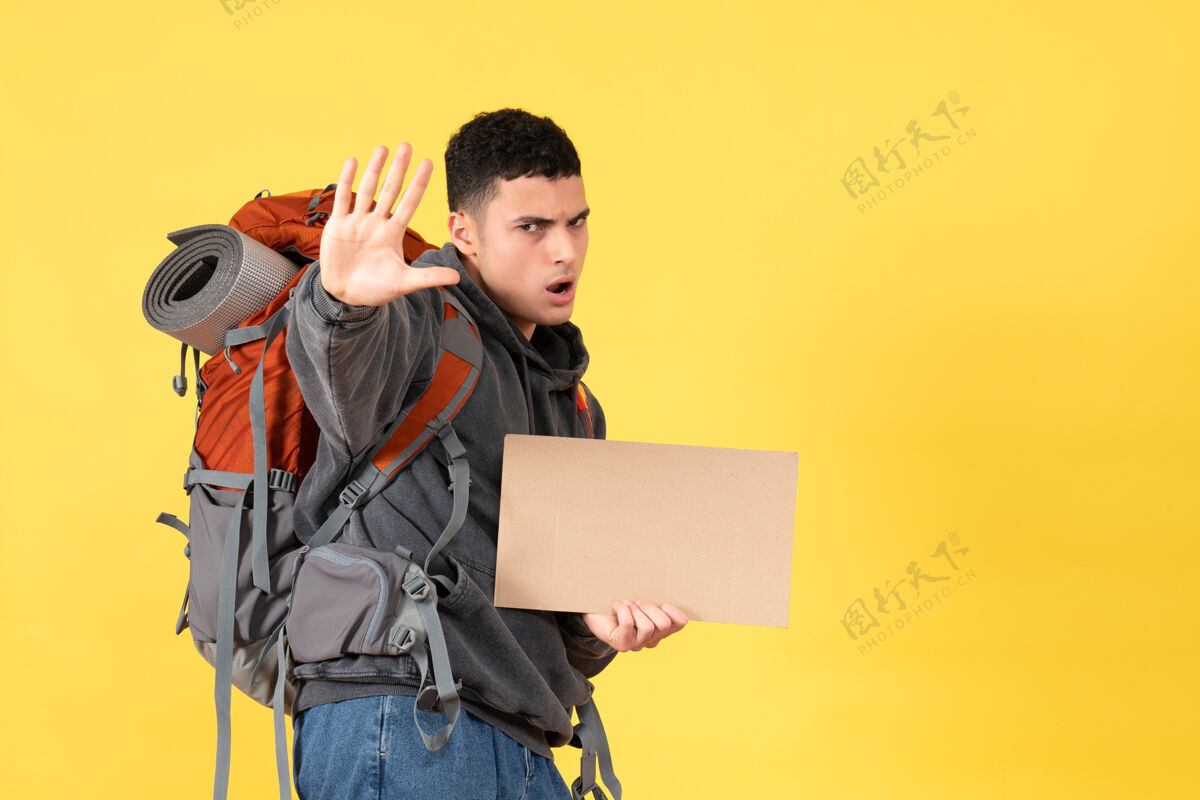 人前视图旅行男子背着背包拿着纸板做停车标志人视图背包