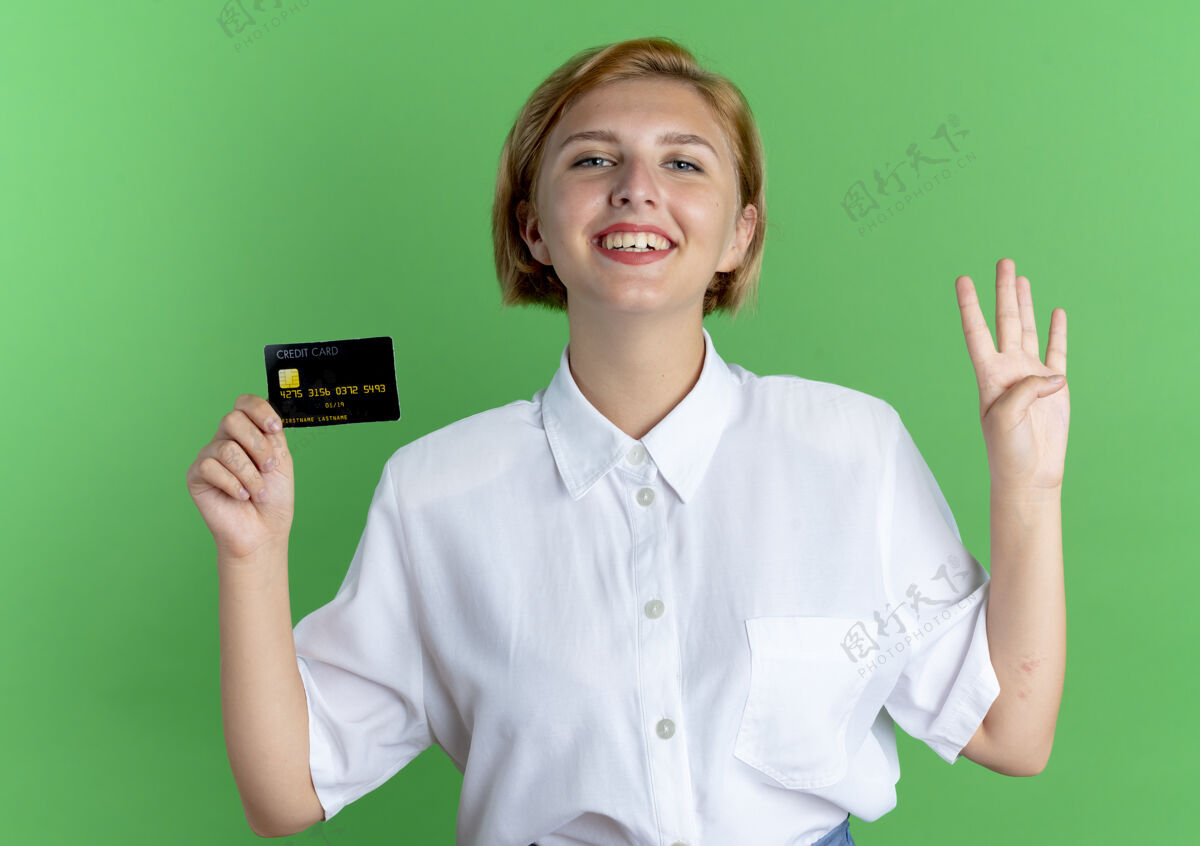 四年轻的微笑金发俄罗斯女孩持有信用卡和手势四四四四