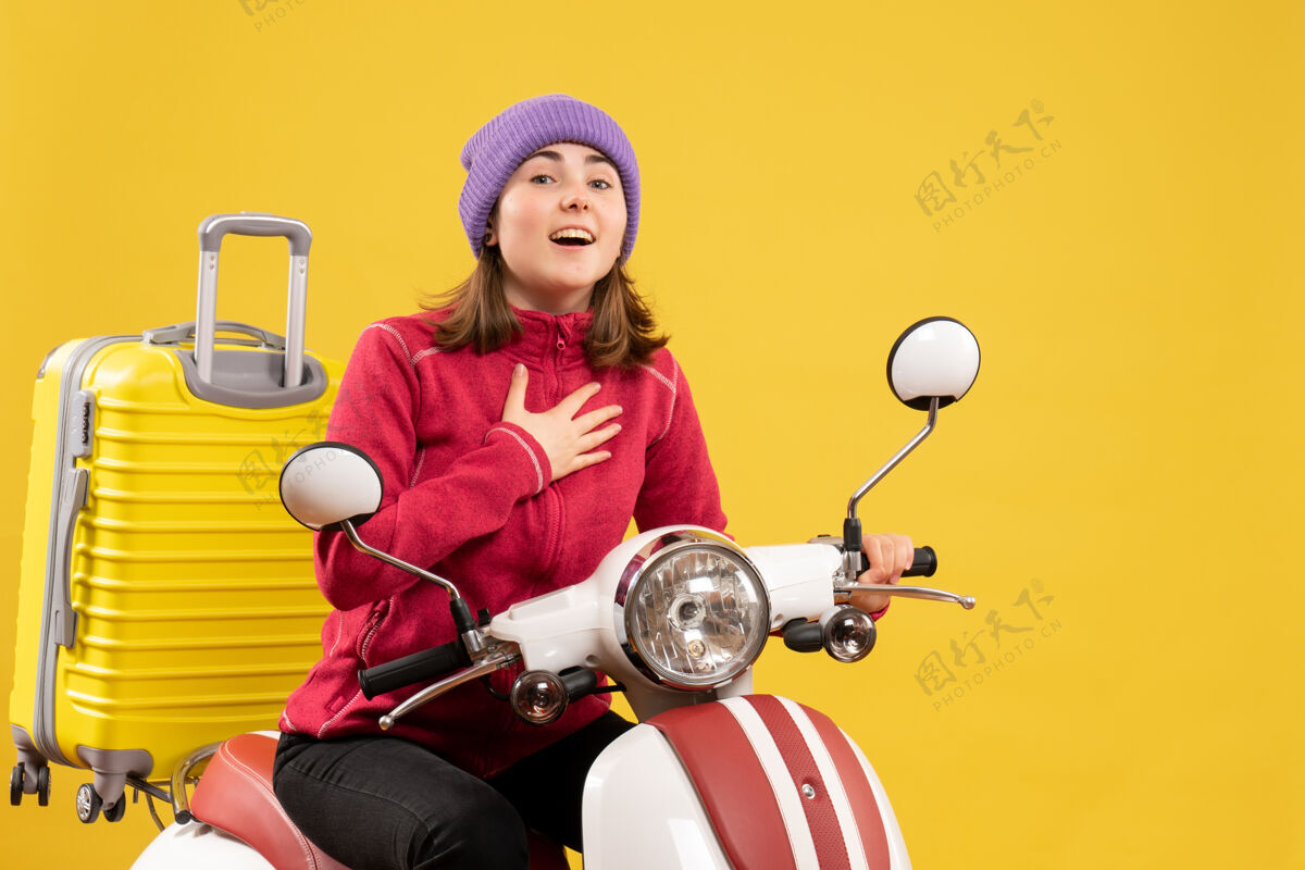 休闲正面图：穿着便服 骑着轻便摩托车的年轻女旅行者衣服前面摩托车
