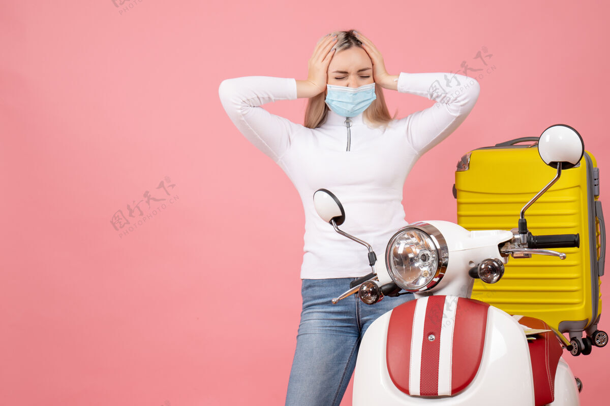 痛苦正面图年轻女士抱着头痛苦地站在轻便摩托车旁边乐趣前面立场