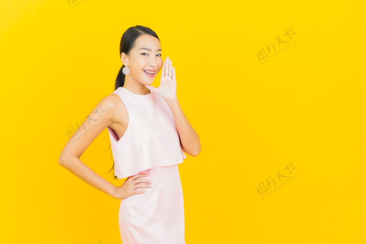 模特肖像美丽的亚洲年轻女子微笑着行动黄色欢呼充满活力成人