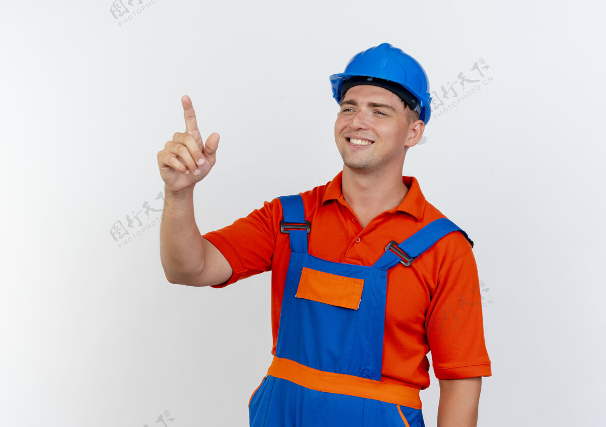 点看着身边微笑的年轻男建筑工人穿着制服和安全帽指着身边白色背景年轻