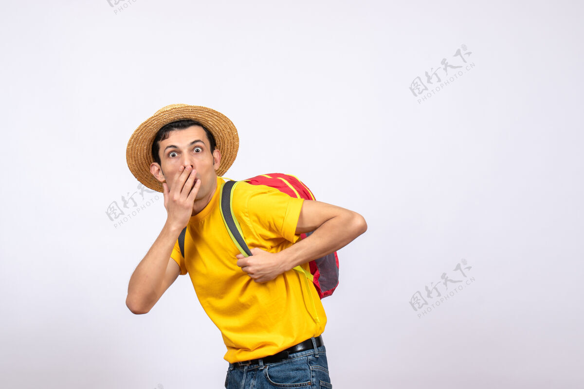 成人正面图：一个戴草帽 穿着黄色t恤的年轻人 手捂着嘴前面手T恤