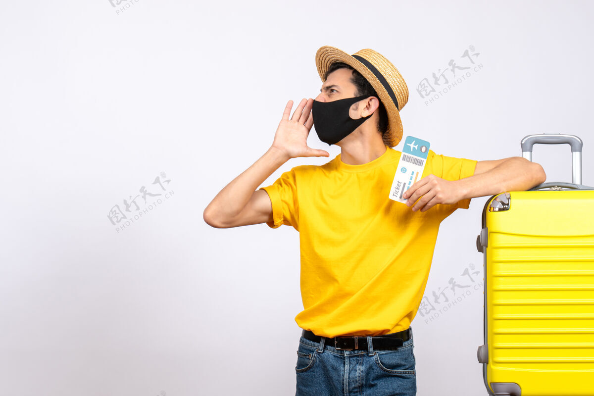 前面正面图：戴着草帽的年轻人站在黄色手提箱旁 手里拿着旅行票 正在叫人年轻人人吸管