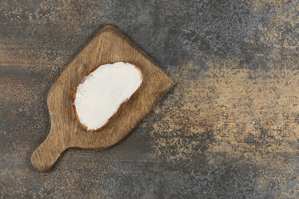 小吃在木板上放一片烤面包和酸奶油正餐奶制品面包