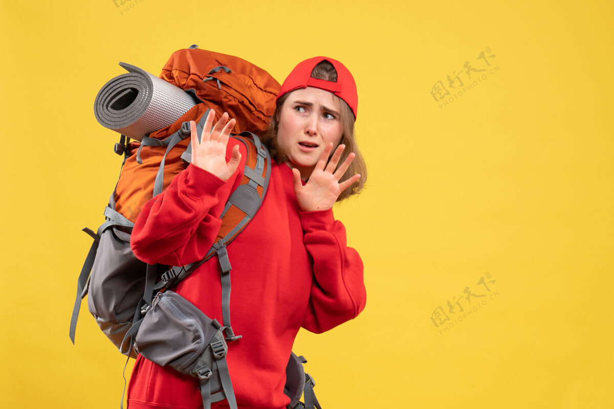 背包前景色吓坏了旅行妇女在红色背包前面帽子成人
